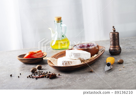 Camembert cheese with figs, raspberry jam. Round brie or camambert cheese on cutting board 89136210