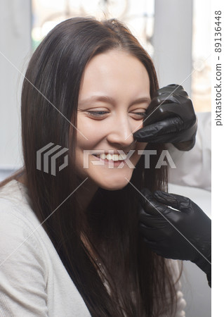 piercings on an ear. Conch and helix piercings close up. Professional holding the jewel. 89136448