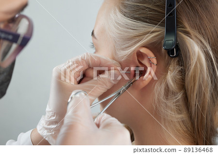 Professional holding the jewel of piercing day just before screw the ball. Tragus type. 89136468