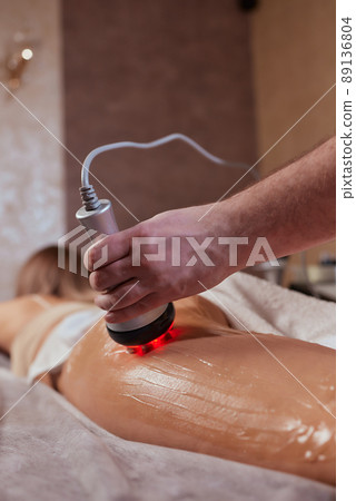 Hardware figure correction. Machine cosmetology. Beautiful woman having cavitation, procedure removing cellulite on her buttocks. Hardware figure correction. Machine cosmetology. Beautiful woman having cavitation, procedure removing cellulite on her buttocks. 89136804