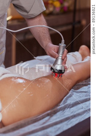 Hardware figure correction. Machine cosmetology. Beautiful woman having cavitation, procedure removing cellulite on her buttocks. Hardware figure correction. Machine cosmetology. Beautiful woman having cavitation, procedure removing cellulite on her buttocks. 89136821