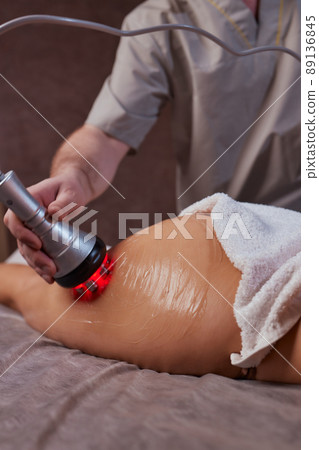 Hardware figure correction. Machine cosmetology. Beautiful woman having cavitation, procedure removing cellulite on her buttocks. Hardware figure correction. Machine cosmetology. Beautiful woman having cavitation, procedure removing cellulite on her buttocks. 89136845