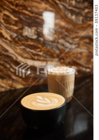 Coffee, a full cup of coffee with milk on the table flower pattern figure which made with crema. Coffee, a full cup of coffee with milk on the table flower pattern figure which made with crema. 89137403