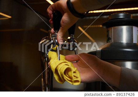 A perfectly lit cleaning cloth sat upon an espresso machine. 89137426