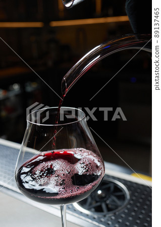 Sommelier man pours red wine into decanter for aeration of taste and aroma. Sommelier man pours red wine into decanter for aeration of taste and aroma. 89137465