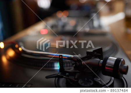 Vinyl record player, bright lights disco-bokeh. Needle on vinyl record. 89137484