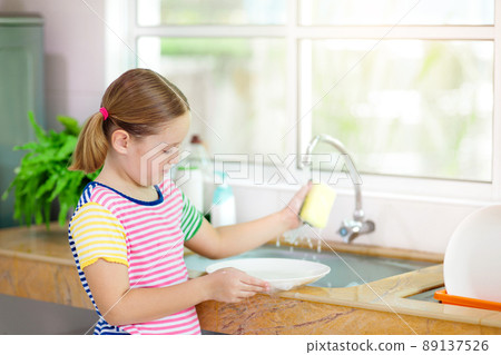 Child washing dishes. 89137526