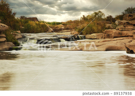 Beautiful mountain river flowing over rocks. Flow of water in mountain river close up Beautiful mountain river flowing over rocks. Flow of water in mountain river close up 89137938