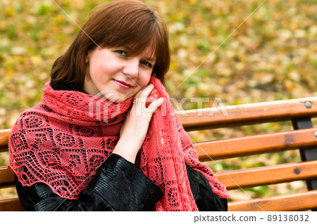 stylish attractive young smiling woman walking down the street in autumn outfit, red knitted scarf, happy mood, fashion style. 89138032