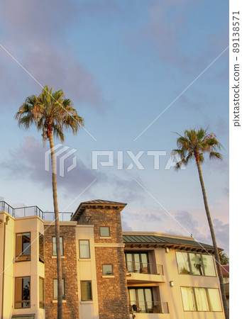 Vertical Puffy clouds at sunset Oceanside building rentals in a low angle view at California 89138571