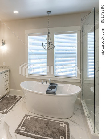 Vertical Luxurious master bathroom with marble tiles and window 89138590