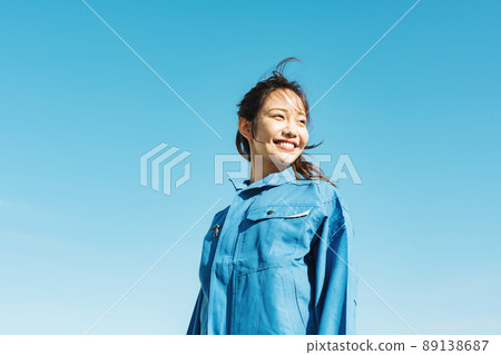 Blue sky portrait of a woman in work clothes 89138687