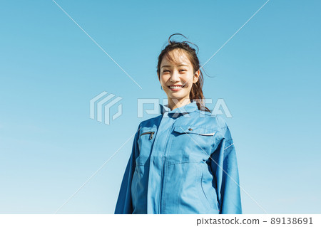Blue sky portrait of a woman in work clothes 89138691