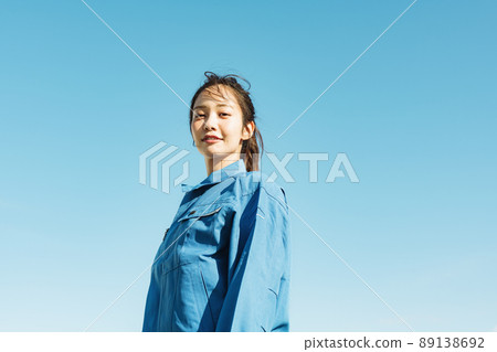 Blue sky portrait of a woman in work clothes Blue sky portrait of a woman in work clothes 89138692
