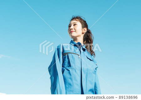 Blue sky portrait of a woman in work clothes 89138696