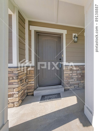 Vertical Porch of a house with white column posts and red arm chair 89138887