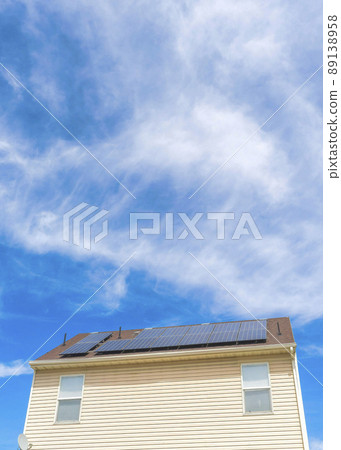 Vertical Whispy white clouds Low angle view of two houses with wood vinyl sidings and solar panels on roof at Utah valley Vertical Whispy white clouds Low angle view of two houses with wood vinyl sidings and solar panels on roof at Utah valley 89138958