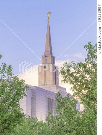 Vertical Puffy clouds at sunset Concrete path with columnar trees on both sides leading to the church 89138997