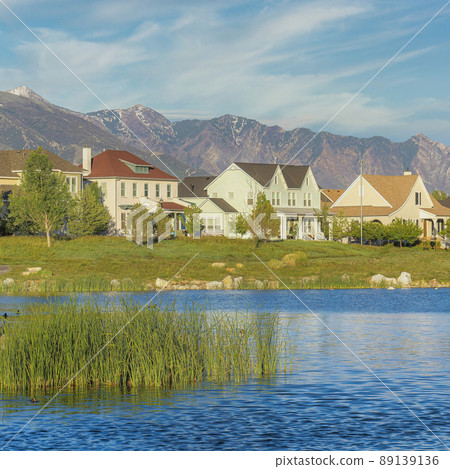 Square Whispy white clouds Oquirrh Lake with curved asphalt walkway on the side at Daybreak Square Whispy white clouds Oquirrh Lake with curved asphalt walkway on the side at Daybreak 89139136