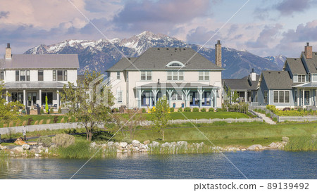 Panorama Puffy clouds at sunset Oquirrh Lake at the front of large residential buildings at Dayb 89139492