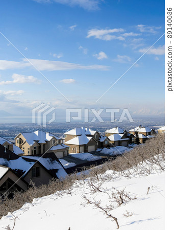 Vertical White puffy clouds High angle view of a residential area covered with snow at Draper, Utah 89140086