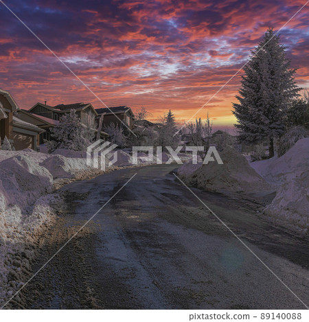 Square Dramatic sunset with clouds Uphill curved road cleared of snow in a residential area at Utah Square Dramatic sunset with clouds Uphill curved road cleared of snow in a residential area at Utah 89140088