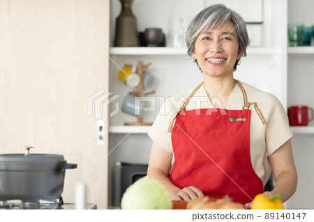 一個 50 多歲的美女站在廚房裡 89140147