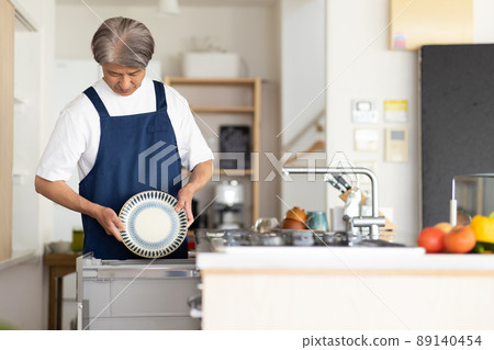 A man washing dishes in the kitchen A man washing dishes in the kitchen 89140454