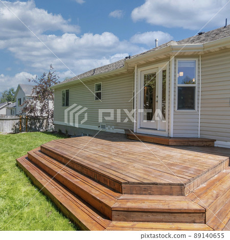 Square White puffy clouds House with wooden layered deck and white back door with glass an Square White puffy clouds House with wooden layered deck and white back door with glass an 89140655