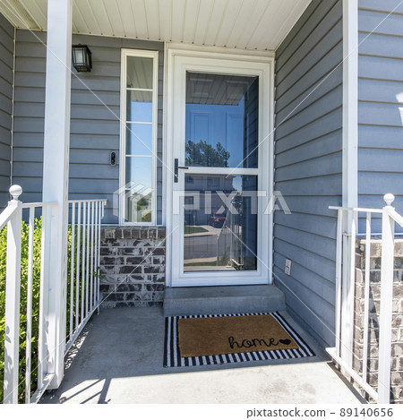 Square Front porch of a house with glass storm door with sidelight 89140656