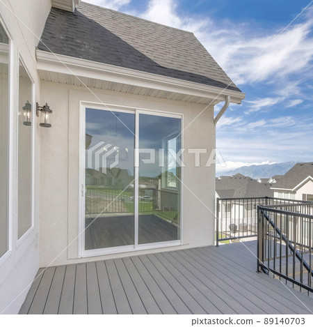 Square Whispy white clouds Deck of a house with stairs, wood flooring, and metal railings Square Whispy white clouds Deck of a house with stairs, wood flooring, and metal railings 89140703