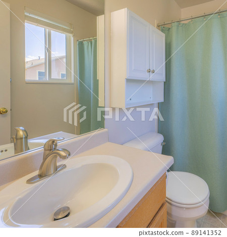 Square Small bathroom with mint green shower curtain and sliding window Square Small bathroom with mint green shower curtain and sliding window 89141352
