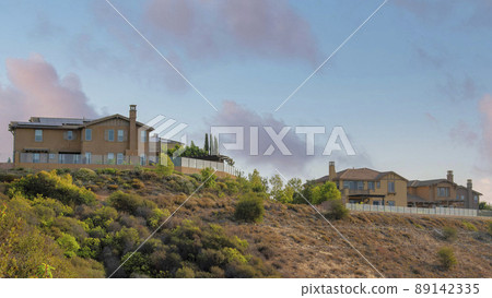 Panorama Puffy clouds at sunset Fenced large houses near the edge of a slope at San Marcos, Cali Panorama Puffy clouds at sunset Fenced large houses near the edge of a slope at San Marcos, Cali 89142335