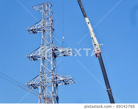 Construction work of a power transmission tower using a crane Construction work of a power transmission tower using a crane 89142788