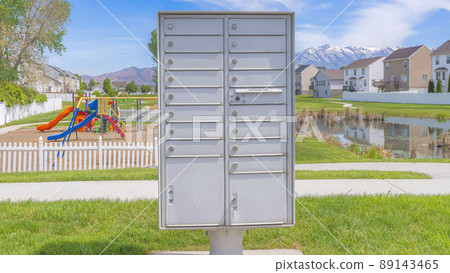Panorama Whispy white clouds Cluster pedestal maibox near the playground and lake in a residential area at Utah valley 89143465