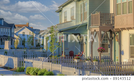 Panorama White puffy clouds Residential buildings exterior with white picket fence and gate 89143512