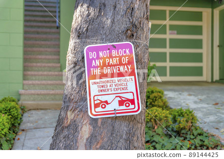 Do not block the driveway signage on a tree trunk at San Francisco, California Do not block the driveway signage on a tree trunk at San Francisco, California 89144425