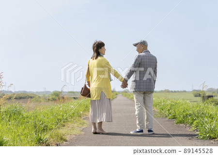 Senior couple holding hands and staring at each other with a smile 89145528