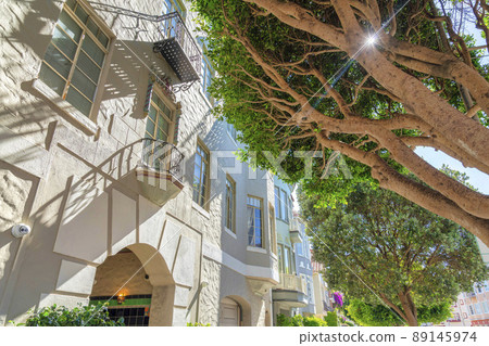 Low angle view of apartment building with beige exterior and window railings in San Francisco, CA 89145974