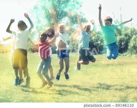 Happy team of friends children jumping together in park Happy team of friends children jumping together in park 89146110