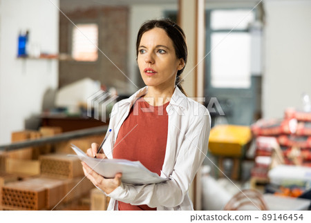 Motivated woman making notes on home space planning during renovation Motivated woman making notes on home space planning during renovation 89146454