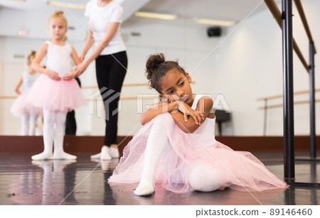 Little upset ballerina sitting on floor Little upset ballerina sitting on floor 89146460