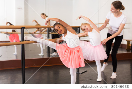 Ballet trainer teaching two little girls Ballet trainer teaching two little girls 89146688