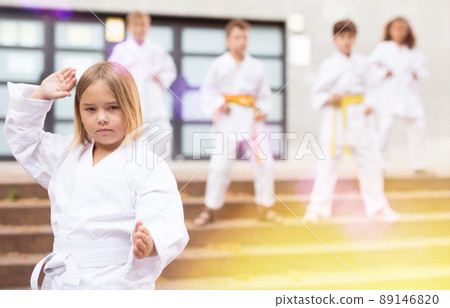 Girl throws a punch at martial arts practice Girl throws a punch at martial arts practice 89146820