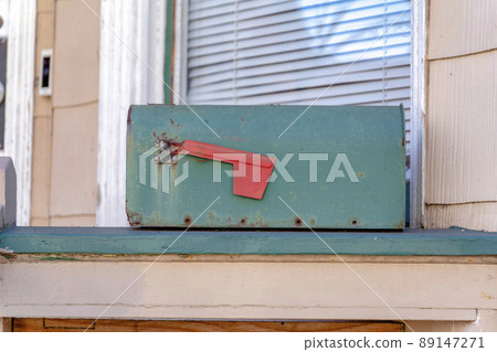Old dark green mailbox on a green wooden surface at San Francisco, California 89147271