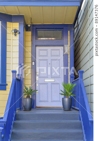 Exterior of a house with blue trims and yellow wood lap sidings at San Francisco, California 89147376