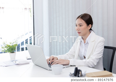 Businesswoman using laptop to work, Asian woman working in the office, World of technology and internet communication, Using computers to conduct financial transactions because the convenience. Businesswoman using laptop to work, Asian woman working in the office, World of technology and internet communication, Using computers to conduct financial transactions because the convenience. 89147976