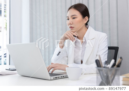 Businesswoman using laptop to work, Asian woman working in the office, World of technology and internet communication, Using computers to conduct financial transactions because the convenience. 89147977