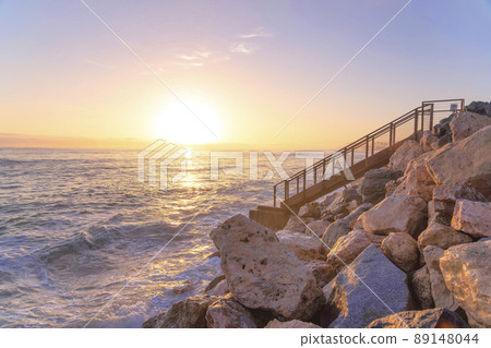 Sunset at San Clemente oceanfront with stairs and rocks in California 89148044