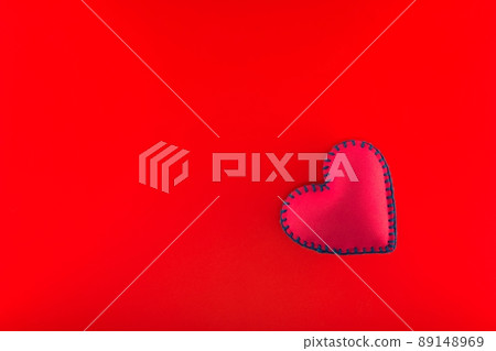 Handmade felt heart over red background Handmade felt heart over red background 89148969